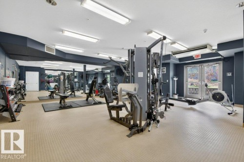 Fitness center with mirrored walls - 223 10121 80 Avenue, Edmonton, AB - Indoor Photo Showing Gym Room