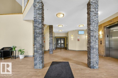 Lobby featuring prominent stacked stone columns - 223 10121 80 Avenue, Edmonton, AB - Indoor Photo Showing Other Room