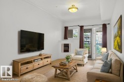 Living area featuring brand new vinyl plank flooring,  crown molding, a built-in electric fireplace and French doors leading to the balcony. This photo has been virtually staged. - 