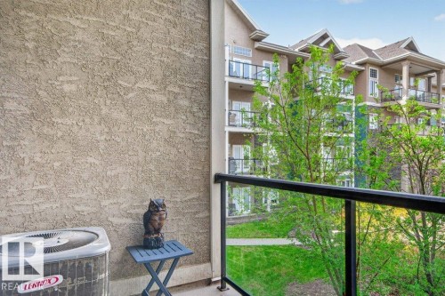 Balcony featuring glass panel railing and stucco exterior - 223 10121 80 Avenue, Edmonton, AB - Outdoor With Balcony