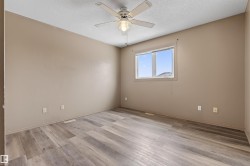 Spacious room featuring wood-finish flooring and neutral wall tones - 