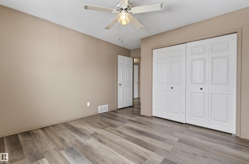 Spacious room featuring wood-finish flooring, a ceiling fan with integrated lighting, and neutral wall tones - 3917 52 Avenue, Cold Lake, AB - Indoor Photo Showing Other Room