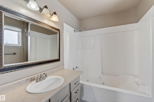 Bathroom featuring a white integrated sink, chrome faucet, and spacious vanity with cabinet storage - 3917 52 Avenue, Cold Lake, AB - Indoor Photo Showing Bathroom
