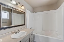 Bathroom featuring a white integrated sink, chrome faucet, and spacious vanity with cabinet storage - 