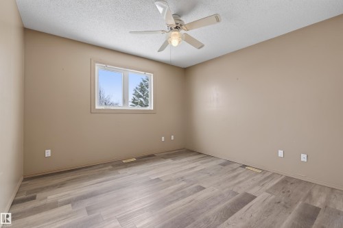 Spacious room featuring wood-finish flooring, a ceiling fan with integrated lighting, and a window with white trim - 3917 52 Avenue, Cold Lake, AB - Indoor Photo Showing Other Room