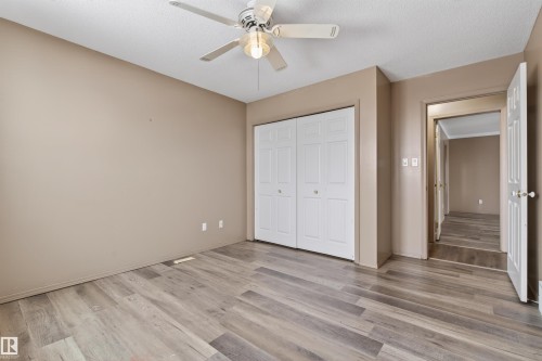 Spacious room featuring wood-finish flooring, neutral-toned walls, and a ceiling fan with integrated lighting - 3917 52 Avenue, Cold Lake, AB - Indoor Photo Showing Other Room