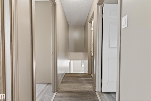 Hallway featuring wood-finish flooring, light-toned walls, and multiple doorways - 3917 52 Avenue, Cold Lake, AB - Indoor Photo Showing Other Room