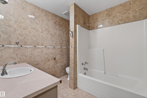 Full bathroom featuring a single vanity with an oval sink, chrome faucet, and a large countertop - 3917 52 Avenue, Cold Lake, AB - Indoor Photo Showing Bathroom