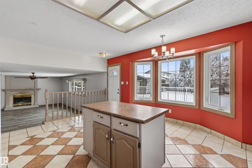 Bright living area featuring a custom fireplace with a decorative mantel, wood-finish flooring, and a ceiling fan - 3917 52 Avenue, Cold Lake, AB - Indoor Photo Showing Other Room