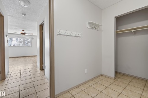 Entryway with tiled flooring, featuring a built-in coat rack, open closet storage with shelving, and light-toned wall finishes - 3917 52 Avenue, Cold Lake, AB - Indoor Photo Showing Other Room