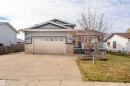 Exterior featuring a two-car garage with a panel door, decorative window inserts, and stucco siding - 3917 52 Avenue, Cold Lake, AB  - Outdoor 