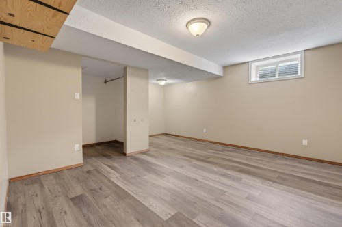 Expansive finished basement featuring wood-finish flooring, recessed ceiling lighting, and a window for natural light - 3917 52 Avenue, Cold Lake, AB - Indoor Photo Showing Other Room