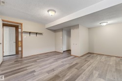 Expansive room featuring wood-finish flooring, neutral-toned walls, and recessed ceiling lighting - 