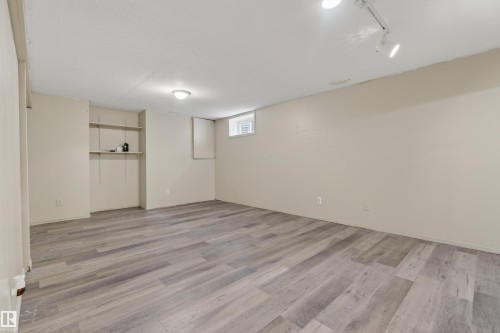 Spacious room featuring light wood-finish flooring, neutral wall tones, built-in shelving, and multiple ceiling light fixtures - 3917 52 Avenue, Cold Lake, AB - Indoor