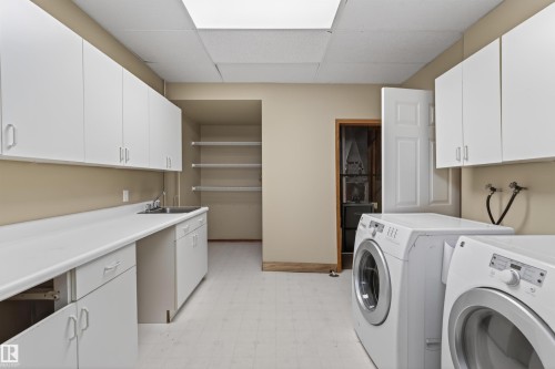 Utility room featuring extensive white cabinetry, a built-in sink, a long countertop, and recessed ceiling lighting - 3917 52 Avenue, Cold Lake, AB - Indoor Photo Showing Laundry Room