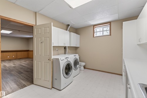 Dedicated laundry area featuring white cabinetry, a utility sink, and ample counter space - 3917 52 Avenue, Cold Lake, AB - Indoor Photo Showing Laundry Room