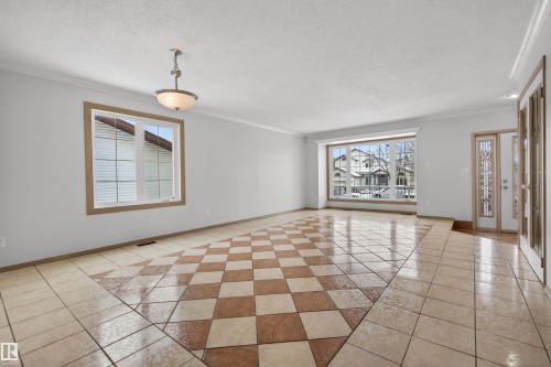 Spacious interior featuring checkerboard tile flooring, large bay window, and a decorative entry door with sidelights - 3917 52 Avenue, Cold Lake, AB - Indoor