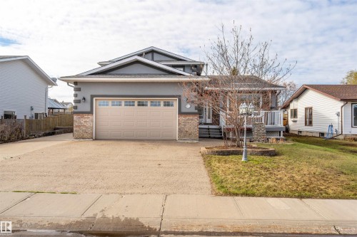 Contemporary home with a double attached garage, a gravel driveway, and a front porch - 3917 52 Avenue, Cold Lake, AB - Outdoor