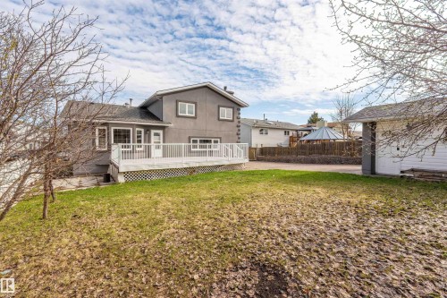 Expansive backyard featuring a multi-level deck with white railing, a separate detached garage, and perimeter fencing - 3917 52 Avenue, Cold Lake, AB - Outdoor With Deck Patio Veranda