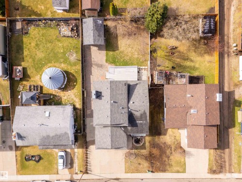 Aerial view showcasing multiple residential properties, featuring shingle roofs and fenced yards - 3917 52 Avenue, Cold Lake, AB - 