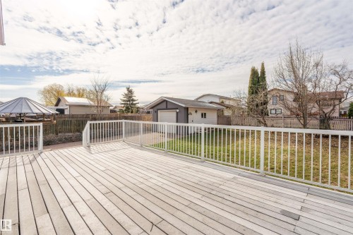 Spacious deck with composite decking and white railing overlooking a fenced yard and detached garage - 3917 52 Avenue, Cold Lake, AB - Outdoor With Deck Patio Veranda