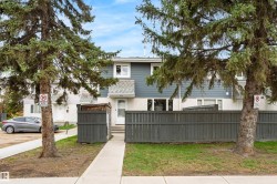 Townhome exterior featuring blue siding with white trim, a gabled entry, and a front walkway leading to the entrance - 