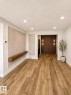 Spacious living area featuring wood-finish flooring, recessed lighting, and a decorative wall panel with a floating wood shelf - 224 Callingwood Two Two, Edmonton, AB  - Indoor Photo Showing Other Room 