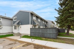 Townhome exterior featuring blue siding and white stucco, a gray privacy fence, and concrete steps - 