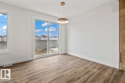 Spacious room featuring wood-finish flooring, white baseboards, and a contemporary ceiling fixture - 