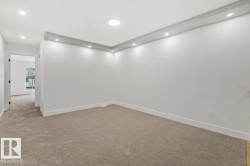 Spacious room featuring neutral carpeting, white baseboards, and recessed ceiling lighting - 