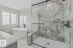 Freestanding soaking tub and walk-in shower with glass enclosure - 