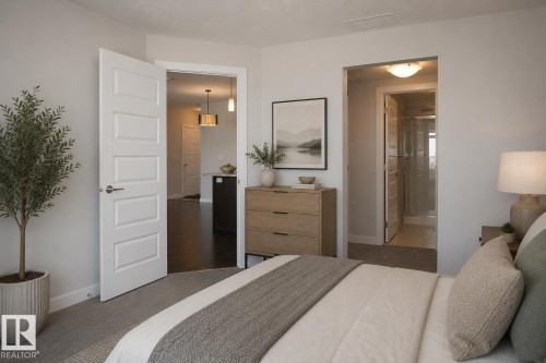 Carpeted bedroom with a light gray color palette, five-panel interior doors, and a wood-finish dresser - 531 5151 Windermere Boulevard, Edmonton, AB - Indoor Photo Showing Bedroom