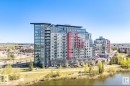 Contemporary high-rise building featuring a glass and panel facade with red accents - 531 5151 Windermere Boulevard, Edmonton, AB  - Outdoor With Body Of Water With Facade With View 