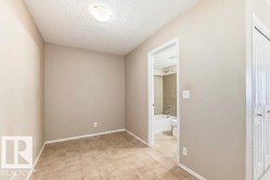 Room with neutral-toned walls, textured ceiling, and square tile flooring - 
