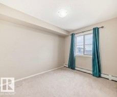Carpeted room featuring a double window with white trim, a flush-mount ceiling light, and baseboard heating - 
