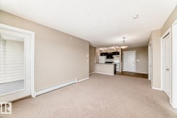Open-concept living area with neutral carpeting and paint tones - 