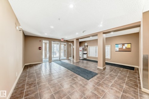 Entry foyer featuring large format tile flooring and neutral wall tones - 404 12025 22 Avenue, Edmonton, AB - Indoor Photo Showing Other Room