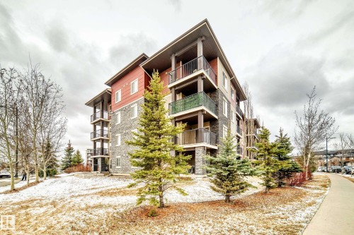 Multi-story residential building featuring stone veneer and horizontal siding - 404 12025 22 Avenue, Edmonton, AB - Outdoor With Balcony