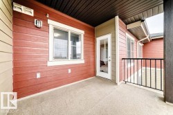 Private balcony featuring textured flooring, red horizontal siding, and white trim - 