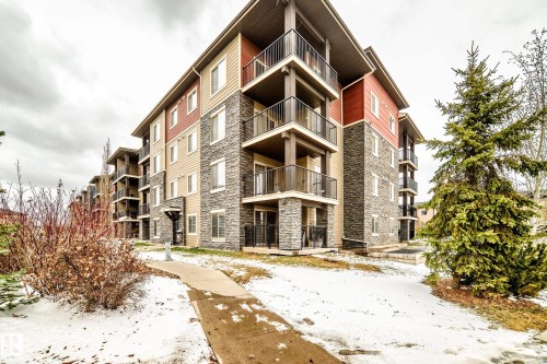 Multi-story residential building featuring a stone and siding exterior - 404 12025 22 Avenue, Edmonton, AB - Outdoor With Balcony With Facade