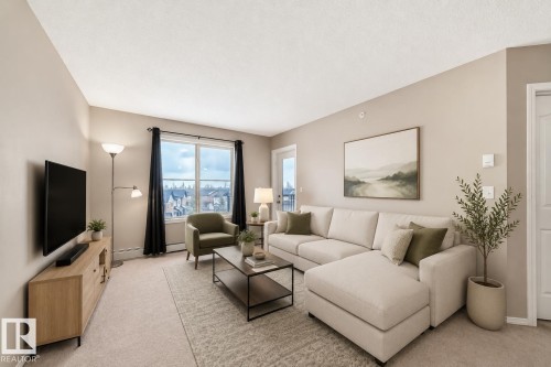 Living area featuring neutral wall tones and light-toned carpeting - 404 12025 22 Avenue, Edmonton, AB - Indoor Photo Showing Living Room