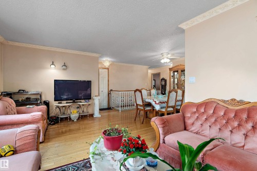 Living area featuring wood-finish flooring, light-toned walls, and decorative crown molding - 15907 101 Street, Edmonton, AB - Indoor Photo Showing Living Room