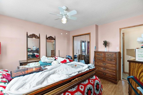 Room with wood-finish flooring, a ceiling fan with light fixture, and a closet with mirrored sliding doors - 15907 101 Street, Edmonton, AB - Indoor Photo Showing Bedroom