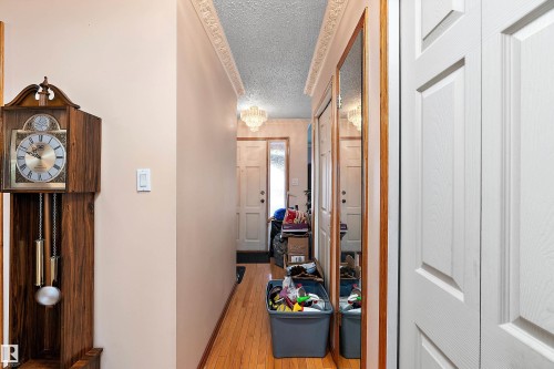 Entryway featuring wood-finish flooring, decorative crown molding, and panel doors - 15907 101 Street, Edmonton, AB - Indoor Photo Showing Other Room