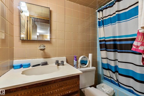 Bathroom featuring a corner vanity with integrated sink, chrome faucet, and rectangular wall-mounted mirror - 15907 101 Street, Edmonton, AB - Indoor Photo Showing Bathroom