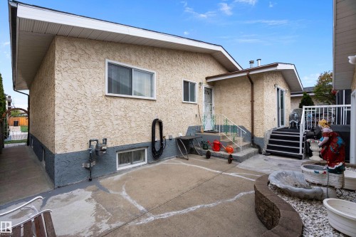 Exterior showcasing stucco siding with a contrasting foundation, multiple entry points, and a concrete patio - 15907 101 Street, Edmonton, AB - Outdoor With Exterior