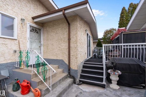 Rear exterior featuring textured stucco siding and a brown gutter system - 15907 101 Street, Edmonton, AB - Outdoor With Exterior