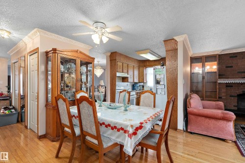 Hardwood-style flooring throughout the open-concept dining area - 15907 101 Street, Edmonton, AB - Indoor Photo Showing Dining Room