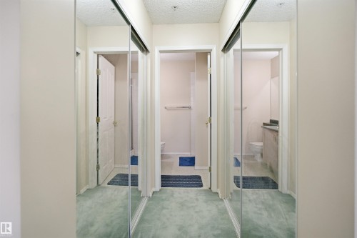 Mirrored closet doors featuring a metal track system and light-colored walls - 124 10511 42 Avenue, Edmonton, AB 