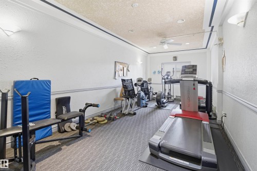 Dedicated fitness space featuring textured walls, crown molding, and a ceiling fan - 124 10511 42 Avenue, Edmonton, AB 